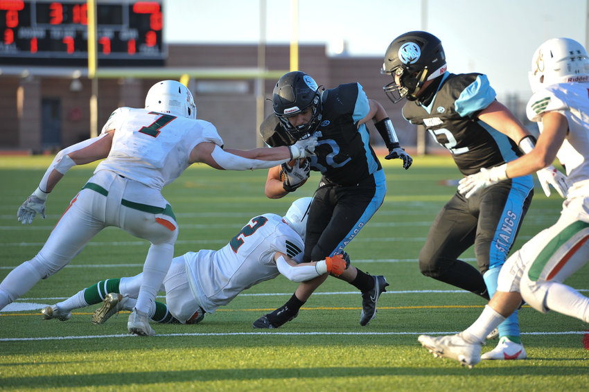 Mountain Range running back Moses Archuleta (32) attempts to escape Adams City's Kris Canterbury (2), and Bo Lapenna (7) during first-quarter action of an April 2 game at District 12 North Stadium in Westminster. The Eagles won 22-21.